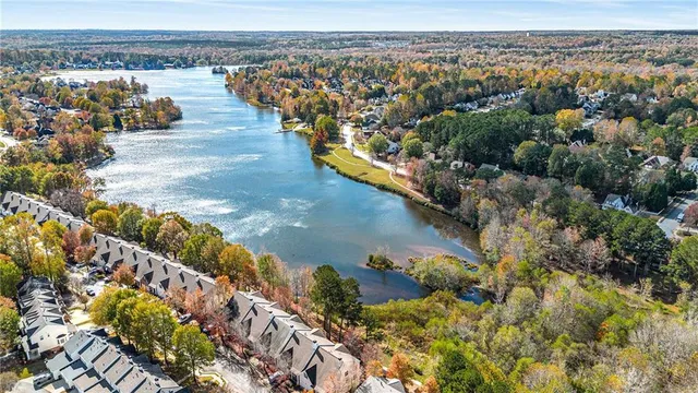 a view of an empty room with wooden floor fireplace and a window