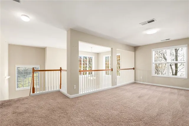 an empty room with chandelier fan and window