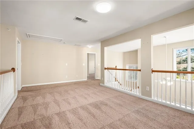 an empty room with chandelier fan and closet area