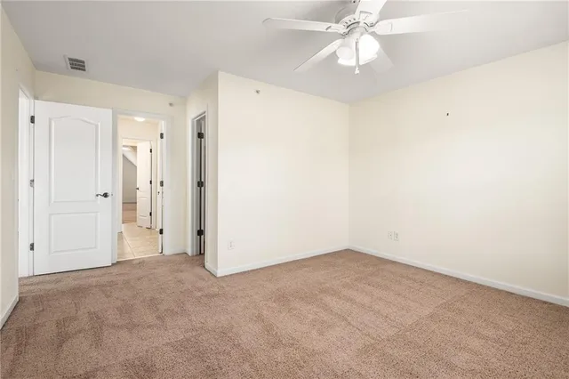 a view of an empty room with a chandelier fan