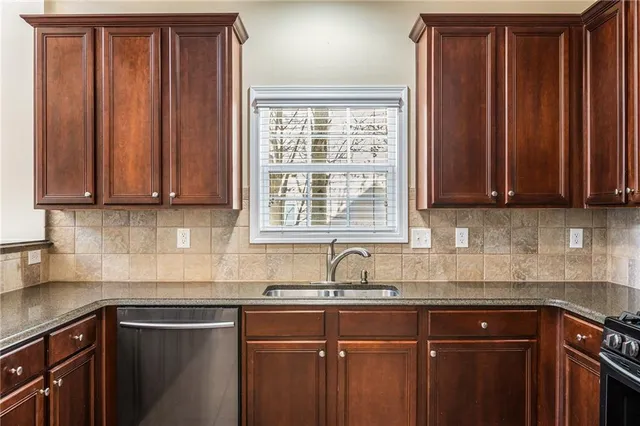 a kitchen with granite countertop wooden cabinets stainless steel appliances and a counter space