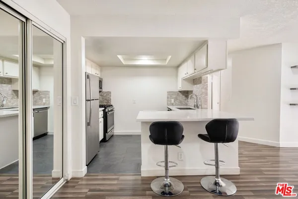 a kitchen with stainless steel appliances granite countertop a sink refrigerator and cabinets