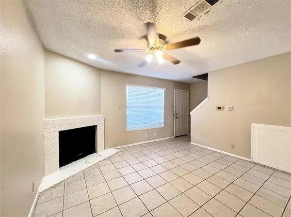 a view of an empty room with a fireplace and a window