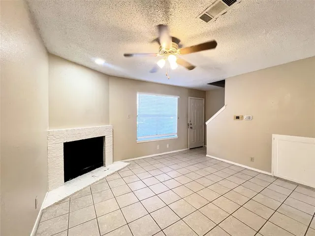 a view of an empty room with a fireplace and a window