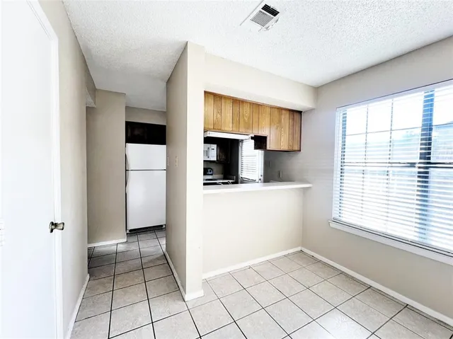 a view of a kitchen & microwave and windows in a room