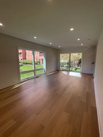 an empty room with wooden floor and a window