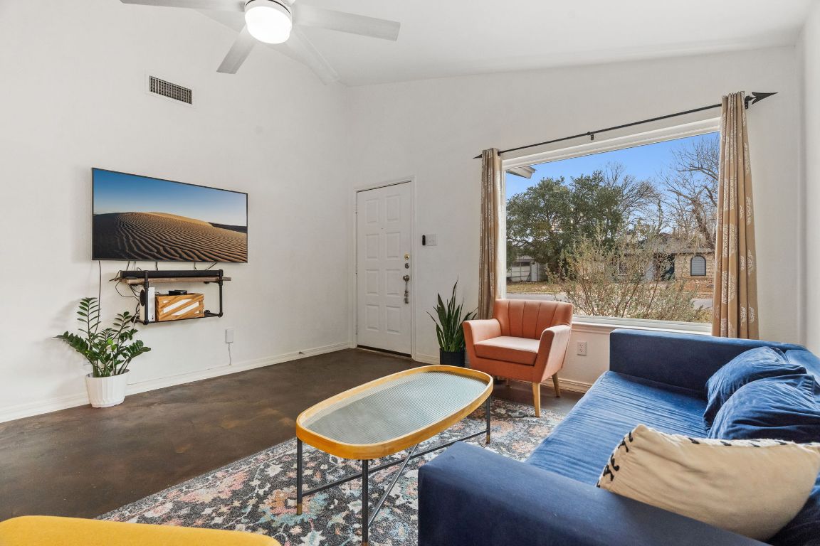 6016 Baton Rouge Drive Austin, TX 78727 - Photo 2 of 29 Living room features concrete floors, an updated ceiling fan, and lofted ceiling