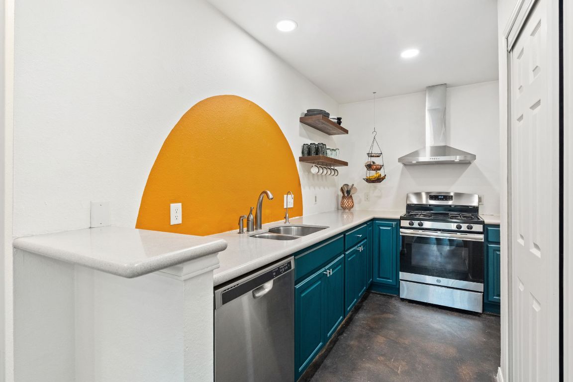 6016 Baton Rouge Drive Austin, TX 78727 - Photo 4 of 29 The happy and stylish kitchen has stainless steel appliances, quartz counters, an updated exhaust hood, and vivid blue cabinets
