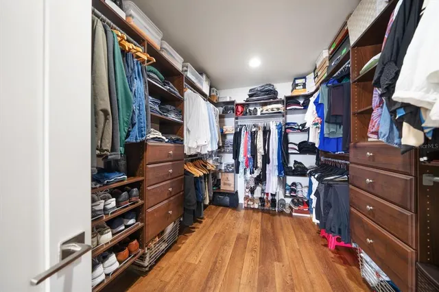 a view of walk in closet with clothes and shoes
