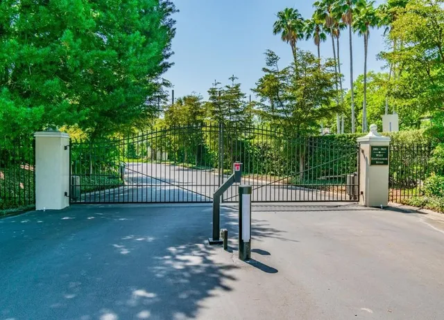 a view of a backyard with brick wall and potted plants