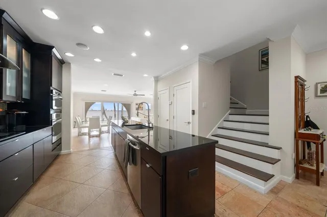 a kitchen with kitchen island granite countertop a sink and a stove top oven