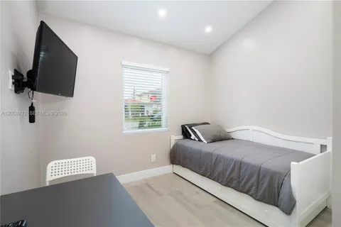 a bedroom with a bed and a flat screen tv