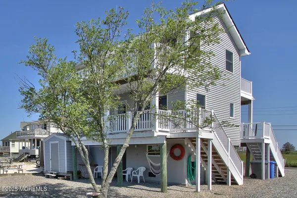 a view of a house with large windows and more tree