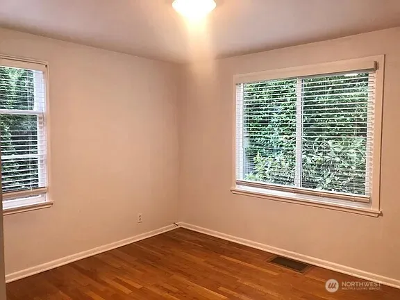 a view of a room with a wooden floor and a window