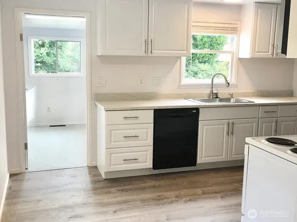 a kitchen with a sink cabinets appliances and a window