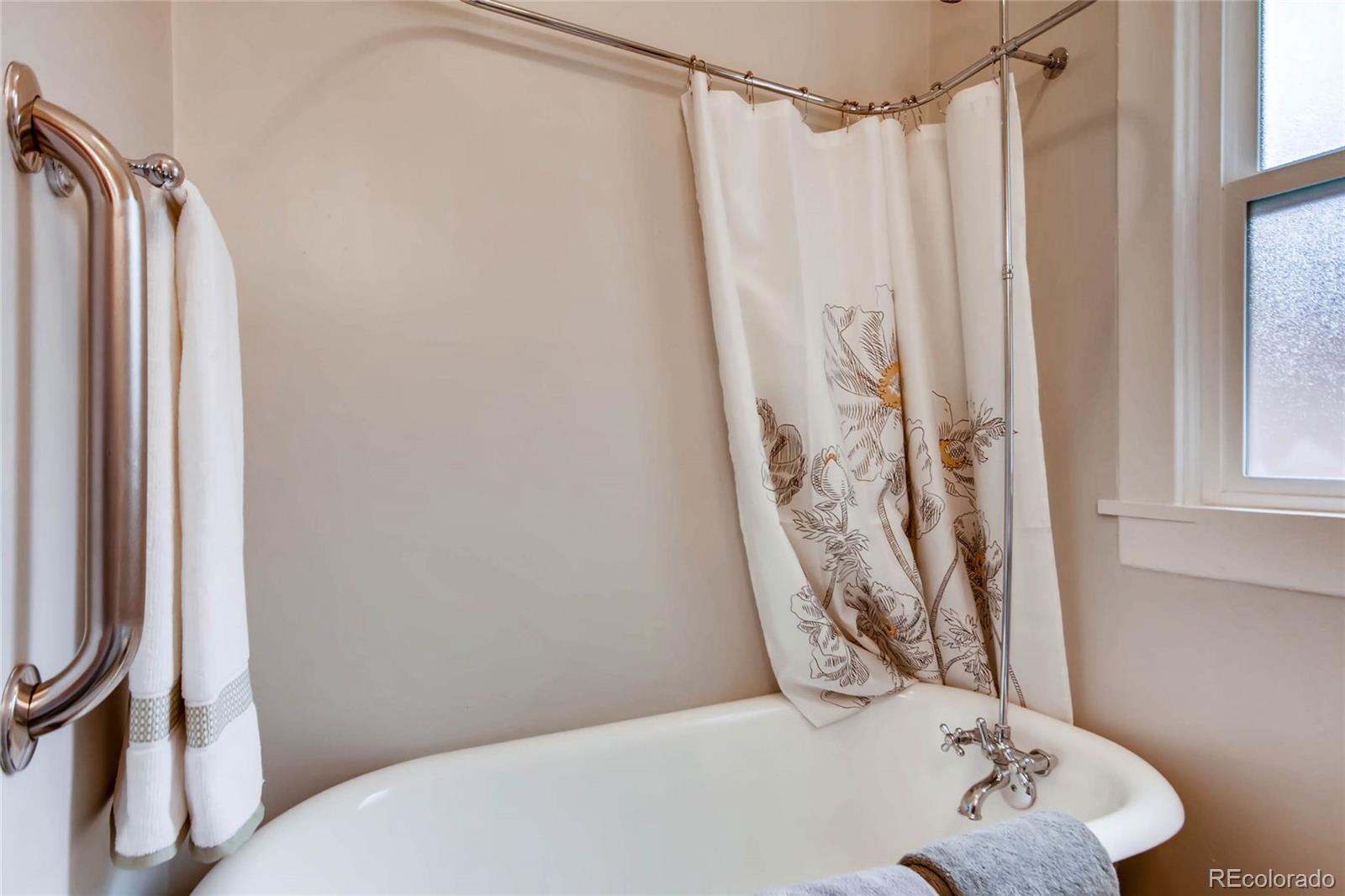 2136 Lowell Boulevard Denver, CO 80211 - Photo 15 of 23 a bathroom with a shower curtain and a window