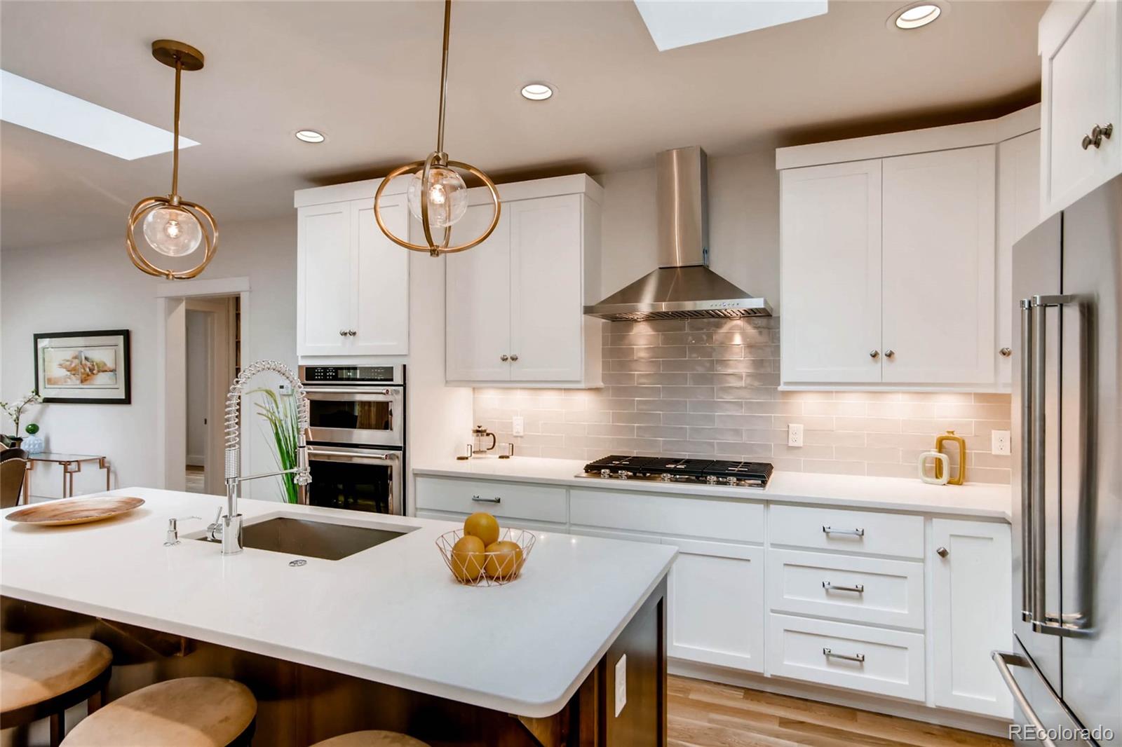 2136 Lowell Boulevard Denver, CO 80211 - Photo 6 of 23 a kitchen with a stove a kitchen island a table and chairs in it