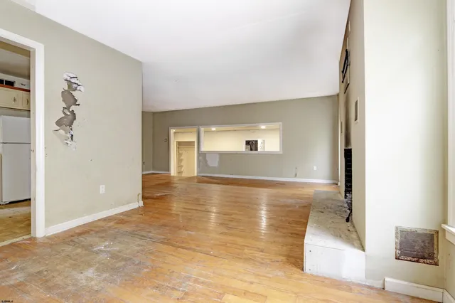 a view of a livingroom with wooden floor and a bathroom
