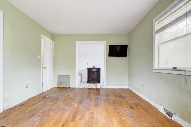 a view of a livingroom with wooden floor and a window