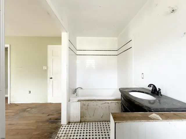 a bathroom with a granite countertop sink a toilet and shower