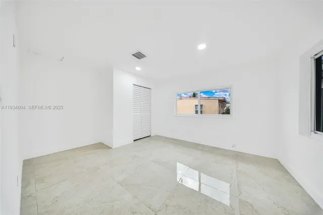 a white kitchen with stainless steel appliances granite countertop a stove and a sink