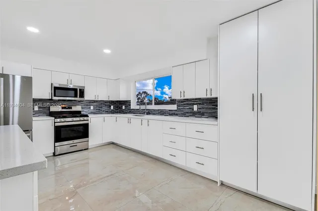 a view of an empty room with kitchen
