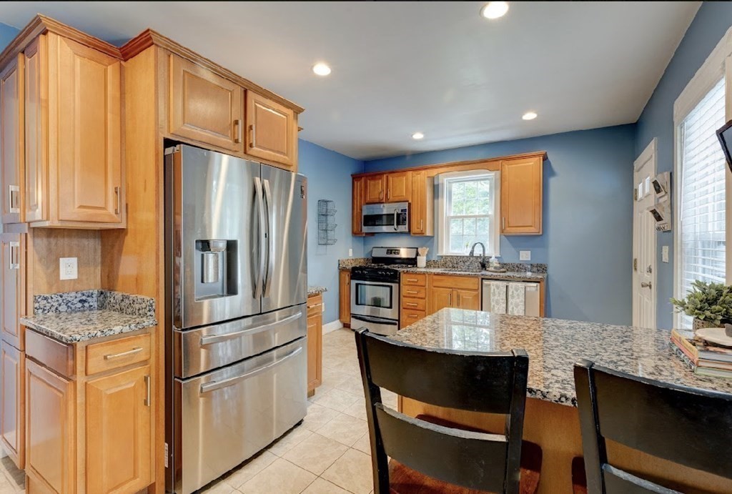 58 Waldo Street Dedham, MA 02026 - Photo 11 of 39 a kitchen with stainless steel appliances granite countertop a refrigerator a stove and a sink