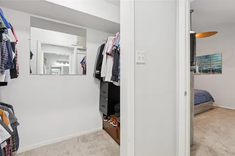 a view of walk in closet with clothes and shoes