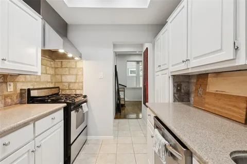 a kitchen with granite countertop a stove and a sink