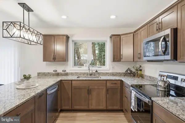 a kitchen with stainless steel appliances granite countertop a sink stove and cabinets