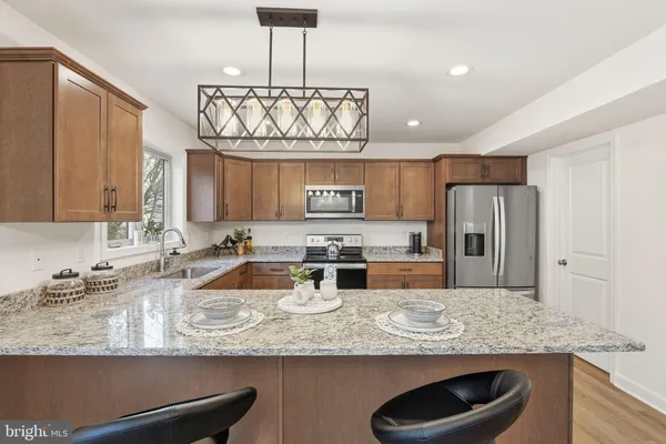 a kitchen with stainless steel appliances granite countertop a sink refrigerator and cabinets