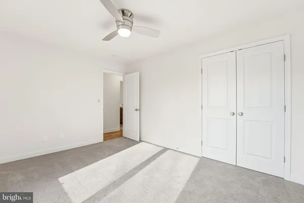 a view of an empty room with a chandelier fan