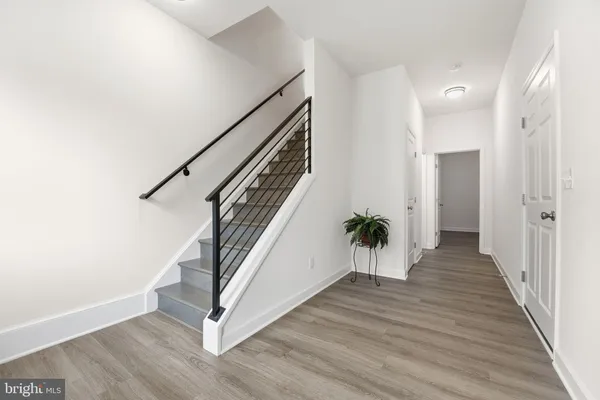 a view of a hallway with wooden floor and staircase