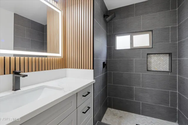 a bathroom with a sink a mirror and shower