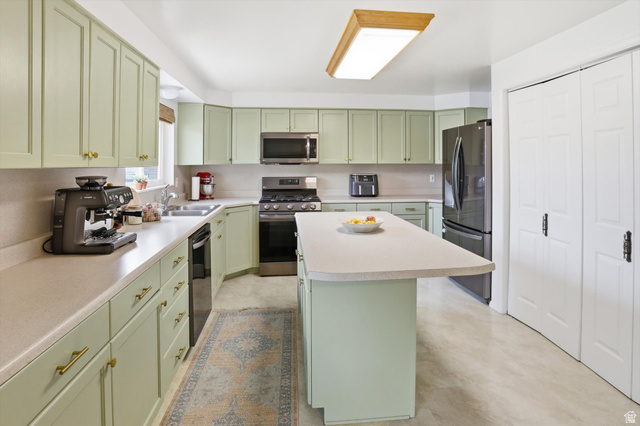 5108 South 2000th Street West Roy, UT 84067 - Photo 16 of 61 Kitchen with green cabinets, stainless steel appliances, light countertops, and a kitchen island