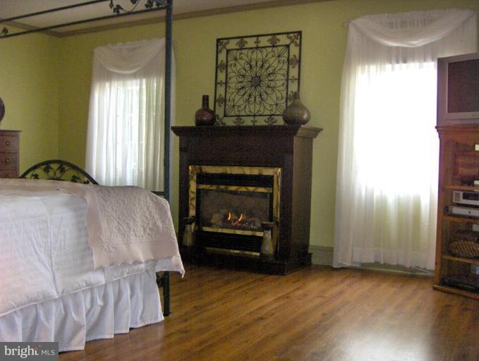 15119 Clear Spring Road Williamsport, MD 21795 - Photo 24 of 30 a bedroom with a bed and a fireplace