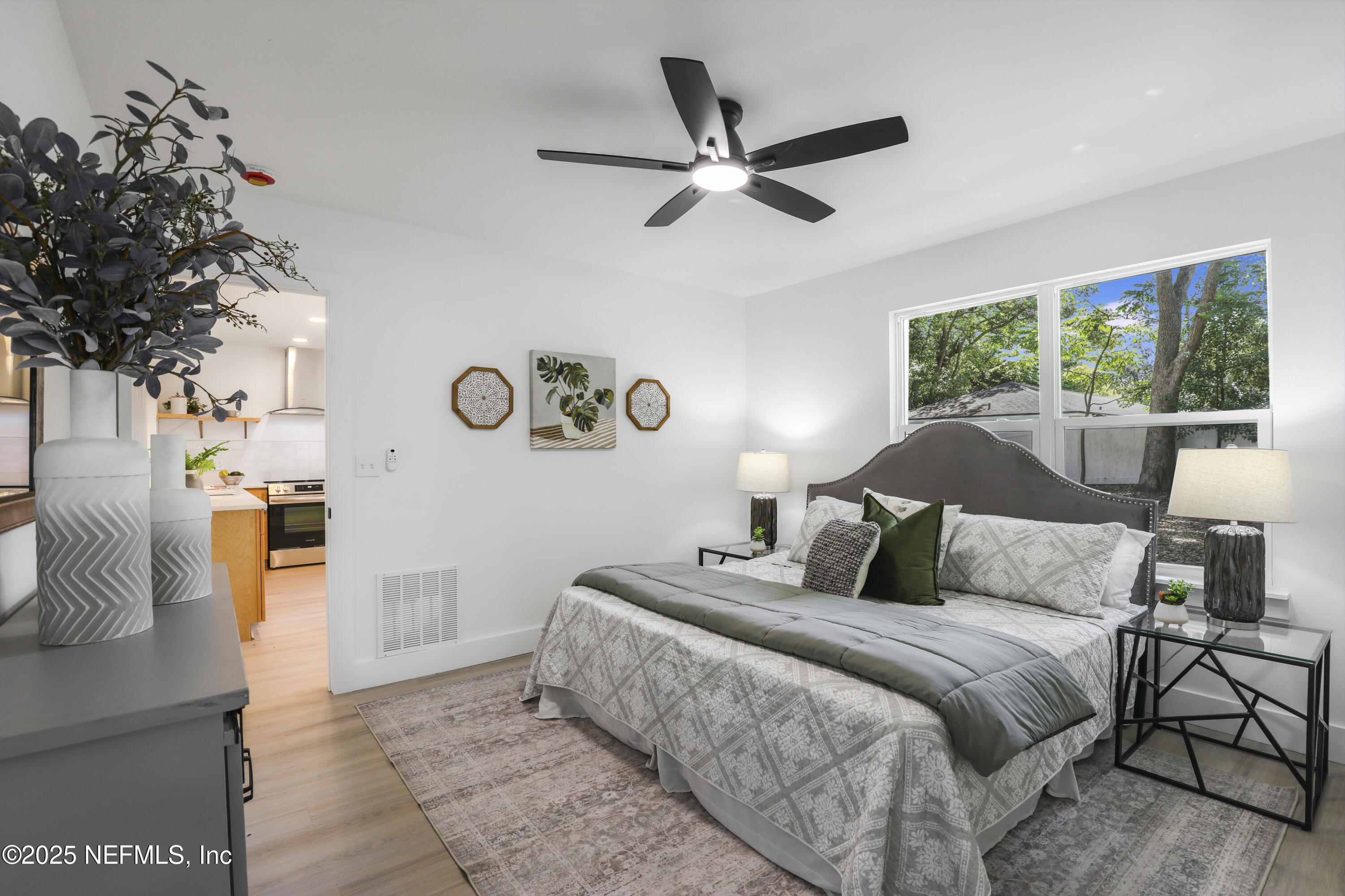 4630 Homestead Road Jacksonville, FL 32210 - Photo 25 of 45 a bedroom with a large bed and a chandelier