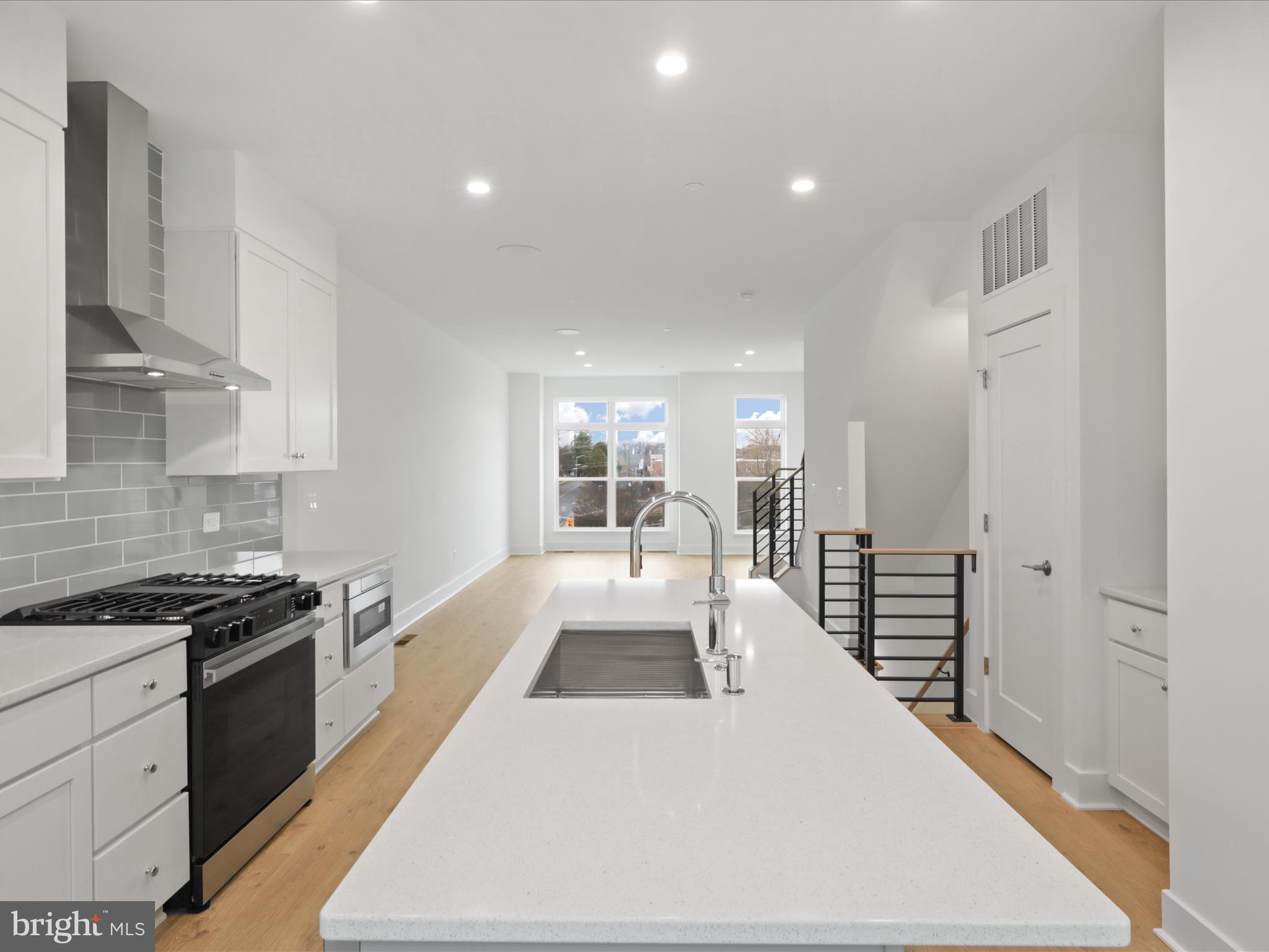 2064 Tysons Ridgeline Road Falls Church, VA 22043 - Photo 14 of 43 a large white kitchen with stainless steel appliances granite countertop a stove a sink a refrigerator and white cabinets
