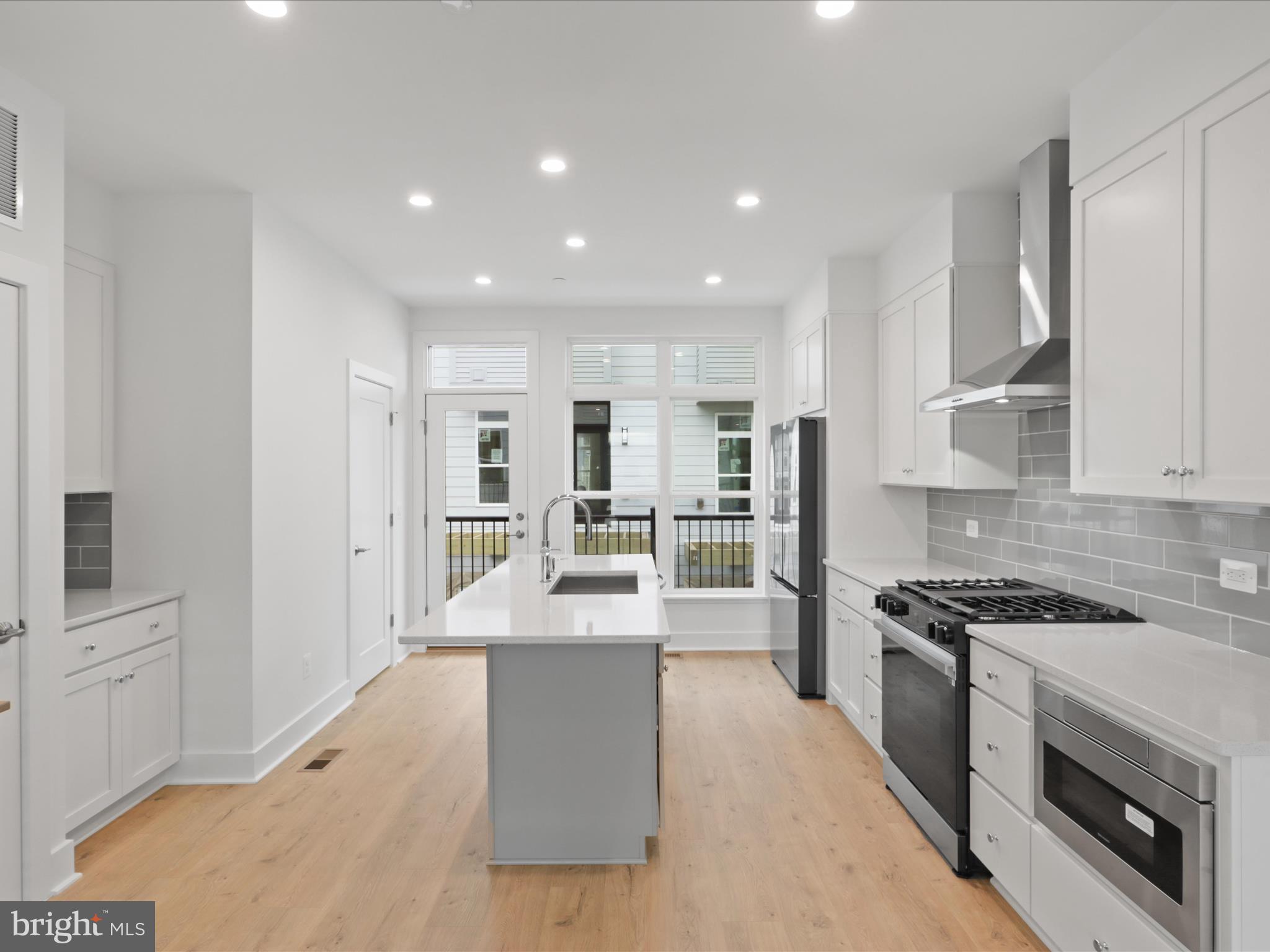 2064 Tysons Ridgeline Road Falls Church, VA 22043 - Photo 10 of 43 a kitchen with stainless steel appliances kitchen island granite countertop a stove and a refrigerator