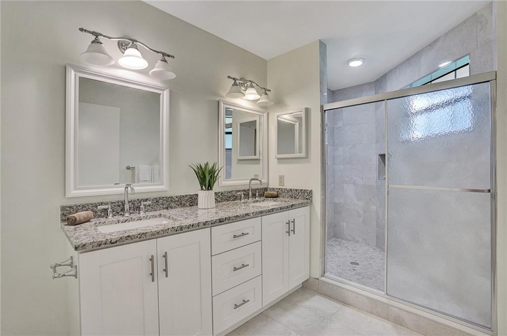 6698 Montego Bay Boulevard, Unit D Boca Raton, FL 33433 - Photo 16 of 44 a bathroom with a granite countertop sink two mirror and shower