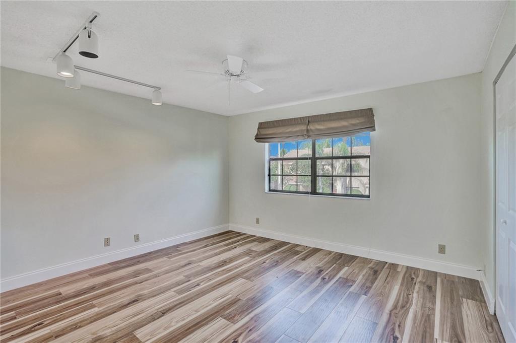 6698 Montego Bay Boulevard, Unit D Boca Raton, FL 33433 - Photo 27 of 44 wooden floor in an empty room with a window