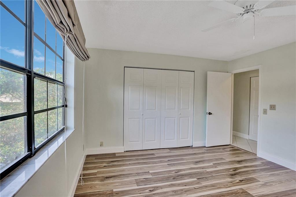 6698 Montego Bay Boulevard, Unit D Boca Raton, FL 33433 - Photo 28 of 44 a view of empty room with wooden floor and fan