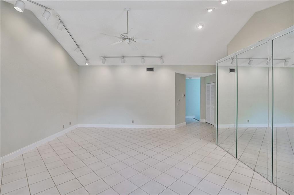 6698 Montego Bay Boulevard, Unit D Boca Raton, FL 33433 - Photo 10 of 44 an empty room with chandelier fan and windows