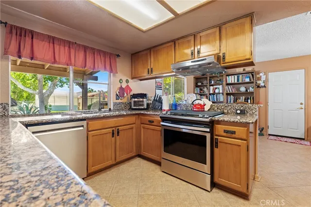 a kitchen with stainless steel appliances granite countertop a stove and a sink