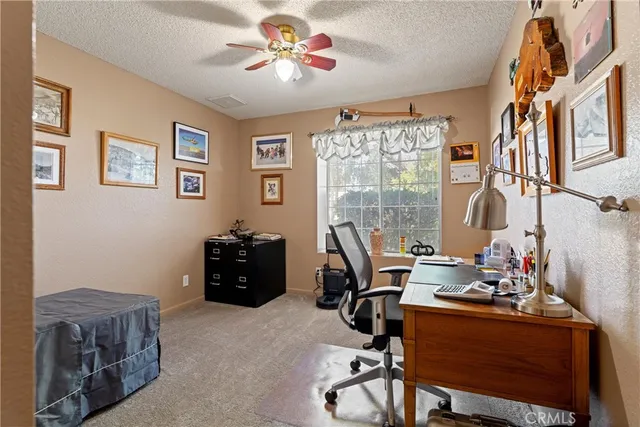 a view of a workspace with furniture and a window