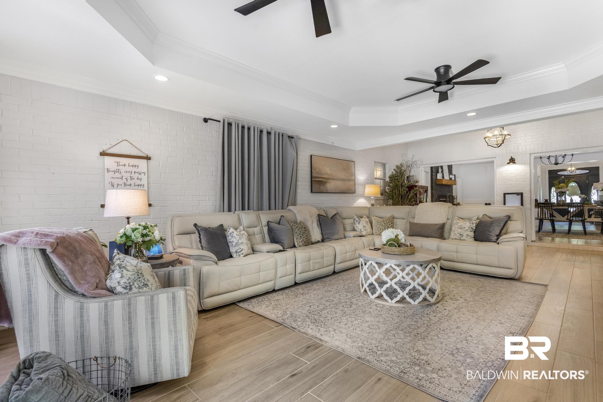 83 Caisson Trace Daphne, AL 36527 - Photo 31 of 63 Spacious living area featuring light wood-finish flooring, a tray ceiling with recessed lighting, and dual ceiling fans