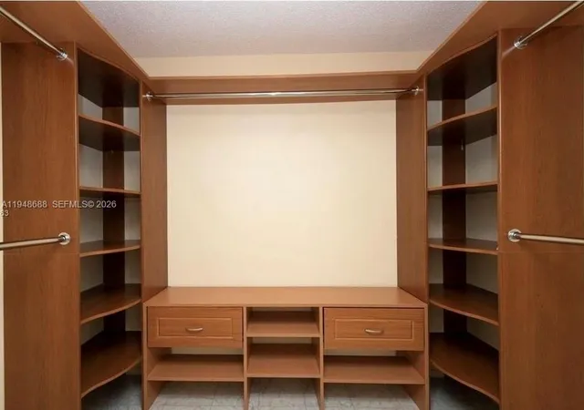 a view of walk in closet with empty racks