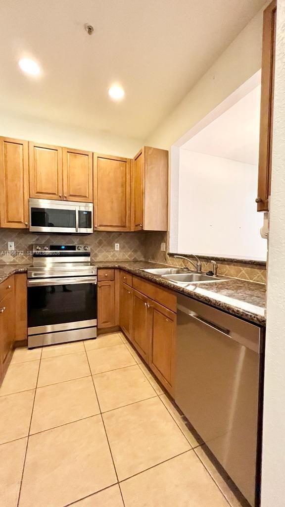 1475 Scilly Cay Lane, Unit 1475 Jupiter, FL 33458 - Photo 21 of 29 a kitchen with a stove a sink and a microwave