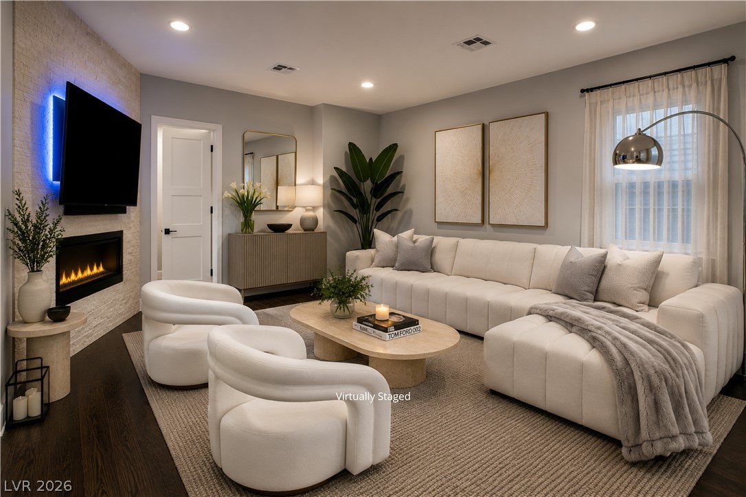 6 Rue Du Ville Henderson, NV 89011 - Photo 10 of 99 “Virtually Staged” living area features a fireplace and hardwood floors, offering a refined space for gatherings.