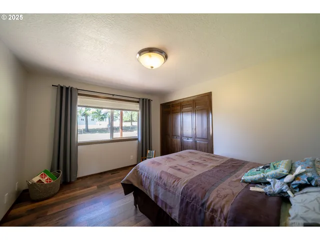 a bedroom with a bed window and wooden floor